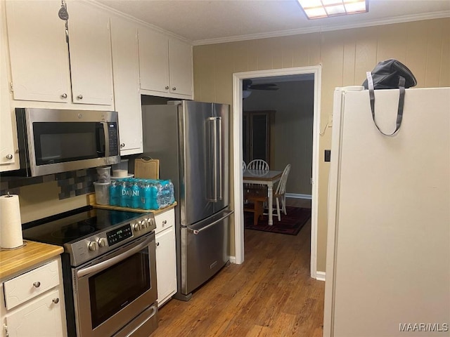 kitchen with light hardwood / wood-style flooring, white cabinets, ornamental molding, and appliances with stainless steel finishes