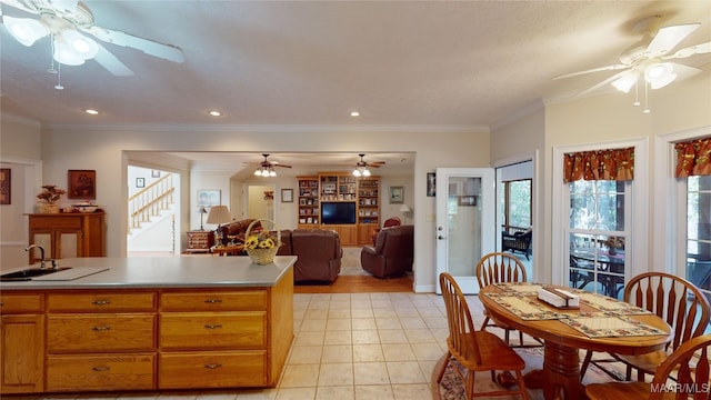 kitchen with sink, light tile patterned floors, and ornamental molding