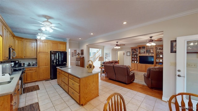 kitchen featuring light tile patterned floors, ornamental molding, a kitchen island with sink, and appliances with stainless steel finishes