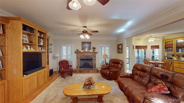 living room featuring a high end fireplace, light hardwood / wood-style floors, and ornamental molding