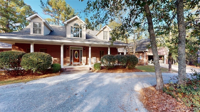 cape cod home featuring a porch