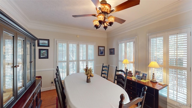 dining space featuring hardwood / wood-style flooring, ceiling fan, crown molding, and a textured ceiling