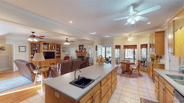 kitchen featuring crown molding, sink, and an island with sink