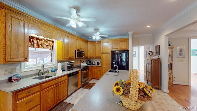 kitchen with crown molding, sink, light wood-type flooring, and appliances with stainless steel finishes