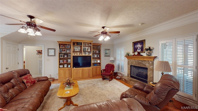 living room with a textured ceiling, wood-type flooring, ornamental molding, and a fireplace