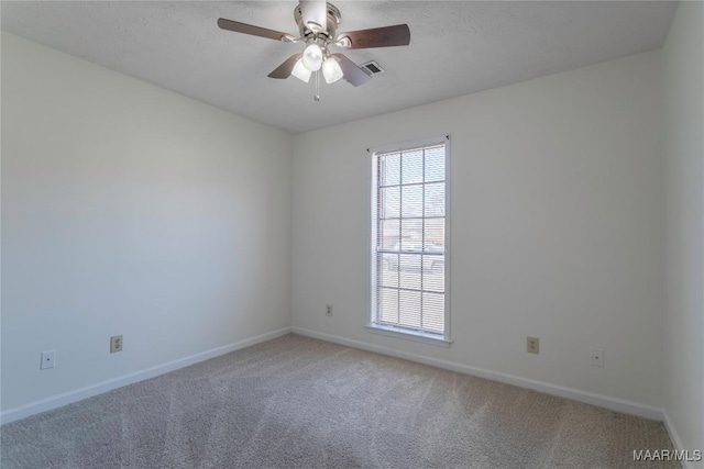 carpeted spare room featuring ceiling fan and a textured ceiling