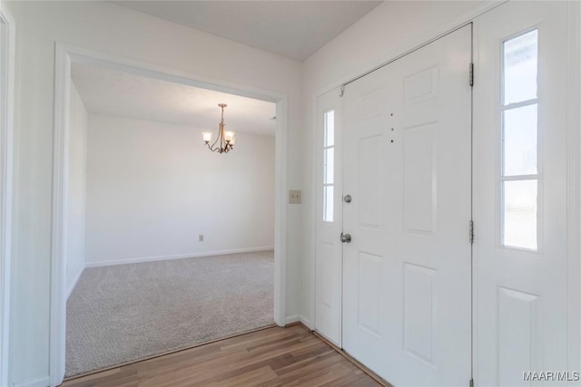 entrance foyer featuring an inviting chandelier, wood-type flooring, and a healthy amount of sunlight