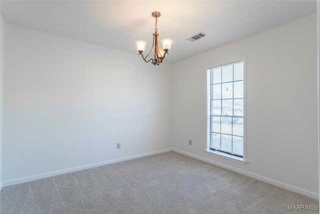 spare room with carpet and an inviting chandelier