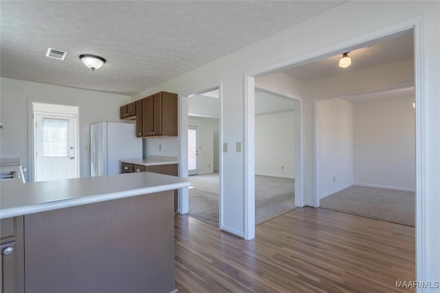 kitchen with white refrigerator, dark hardwood / wood-style floors, a wealth of natural light, and a textured ceiling