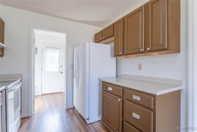 kitchen featuring white appliances and light wood-type flooring