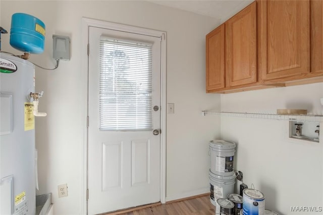 doorway with light hardwood / wood-style floors and water heater