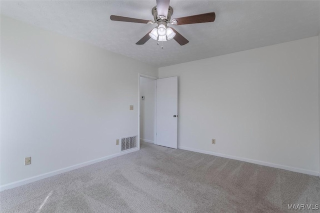 carpeted spare room featuring ceiling fan