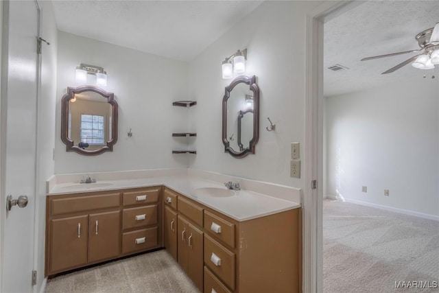 bathroom featuring ceiling fan, vanity, and a textured ceiling