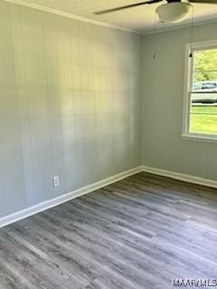 spare room featuring crown molding and dark wood-type flooring