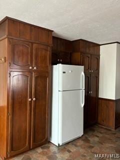 kitchen with white fridge and wood walls