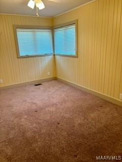 carpeted empty room with ceiling fan and ornamental molding