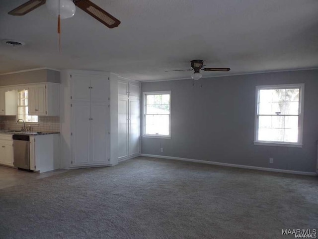 unfurnished living room with plenty of natural light, carpet floors, and ornamental molding