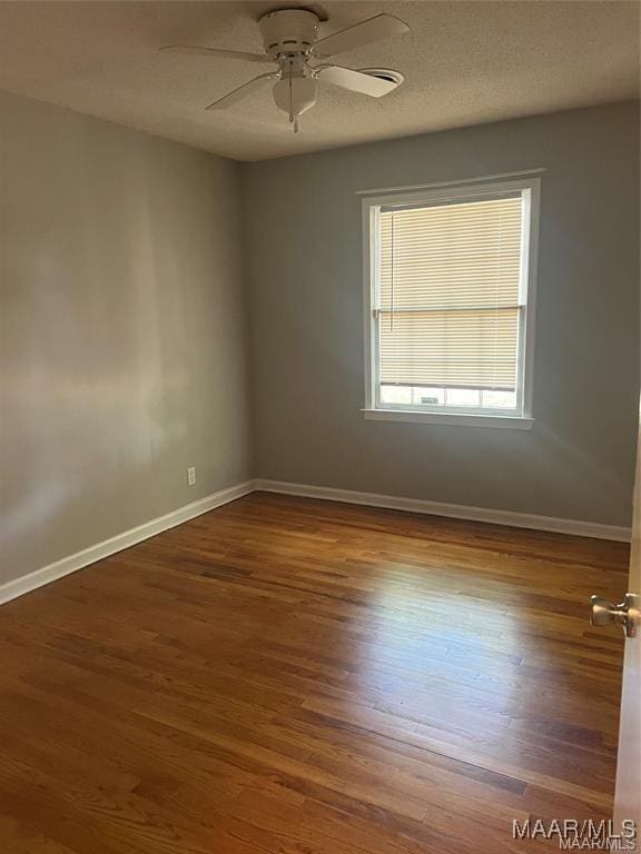 empty room with ceiling fan and dark hardwood / wood-style flooring