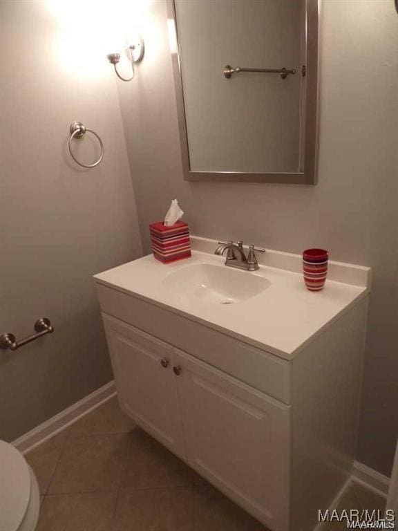 bathroom featuring tile patterned flooring, vanity, and toilet