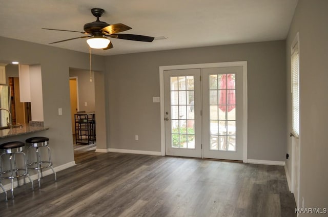 unfurnished living room featuring dark hardwood / wood-style flooring and ceiling fan