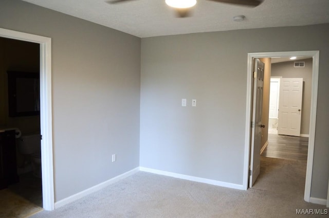 unfurnished room with a textured ceiling, light colored carpet, and ceiling fan