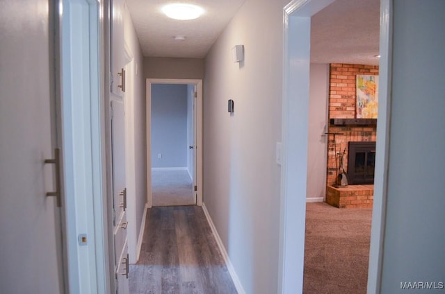 corridor with a textured ceiling and hardwood / wood-style flooring