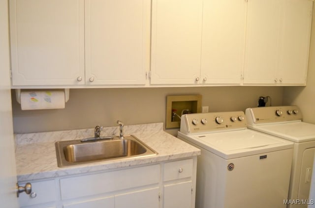 washroom featuring sink, cabinets, and independent washer and dryer