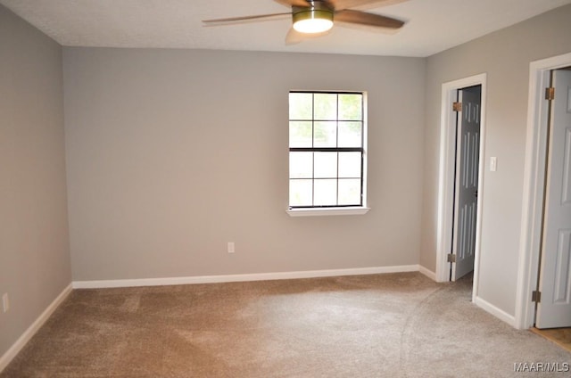 carpeted empty room featuring ceiling fan