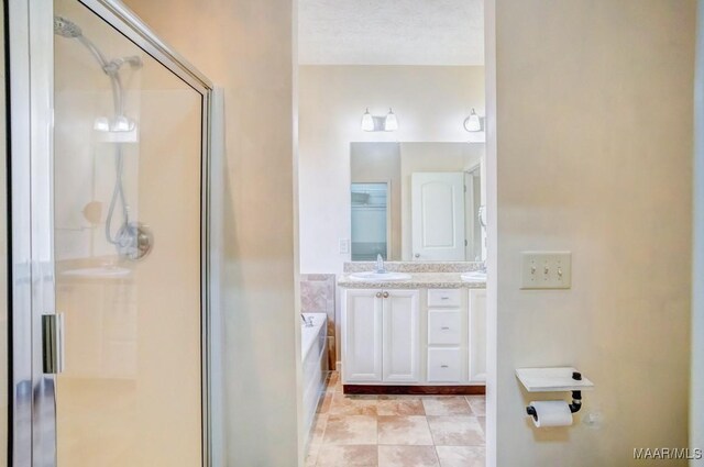 bathroom with tile patterned flooring, vanity, a textured ceiling, and independent shower and bath