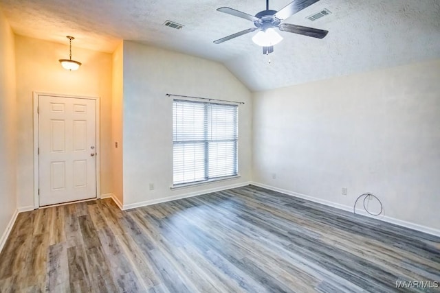 interior space with a textured ceiling, ceiling fan, lofted ceiling, and dark wood-type flooring