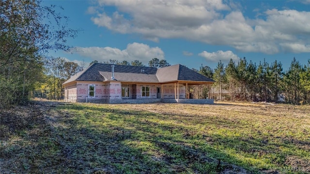 rear view of property with a lawn