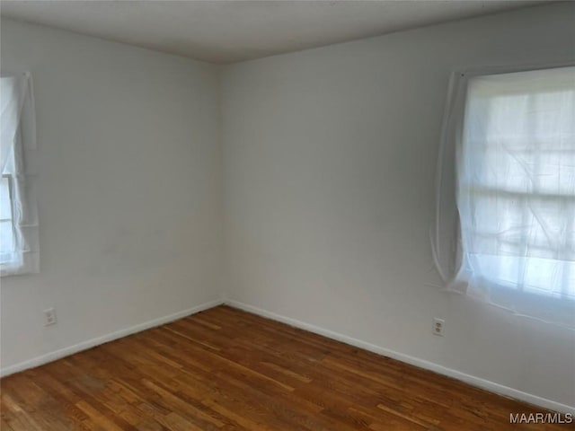 spare room with dark wood-type flooring