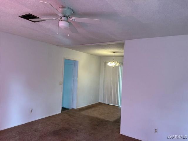 unfurnished room featuring dark colored carpet, ceiling fan with notable chandelier, and a textured ceiling