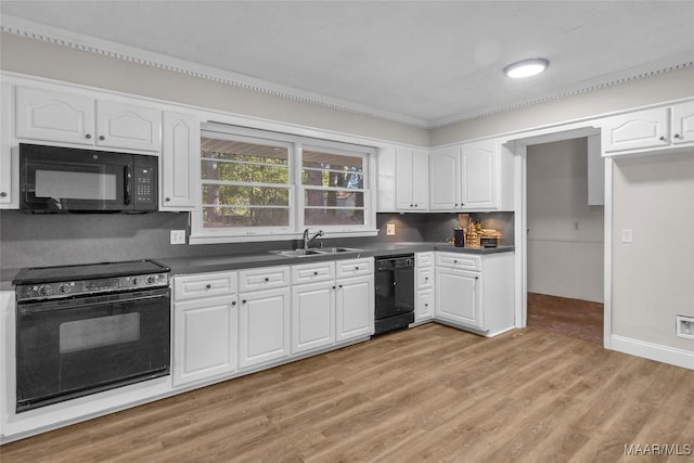 kitchen featuring black appliances, white cabinets, and light hardwood / wood-style flooring