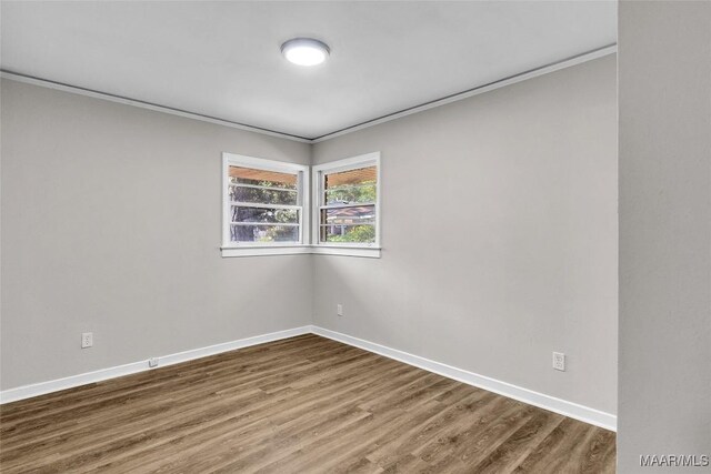 unfurnished room with hardwood / wood-style flooring and crown molding