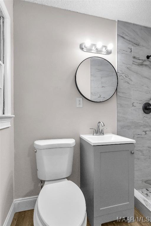 bathroom with vanity, wood-type flooring, a textured ceiling, and toilet