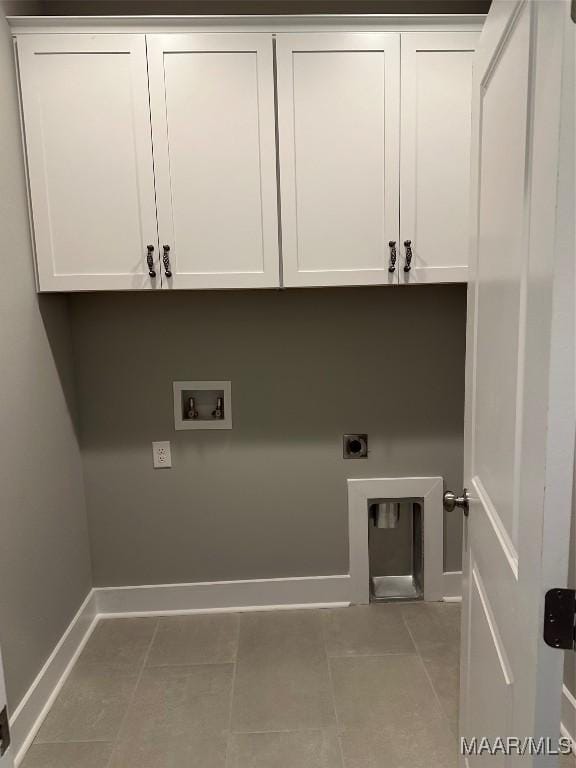 clothes washing area with hookup for an electric dryer, cabinets, light tile patterned floors, and washer hookup