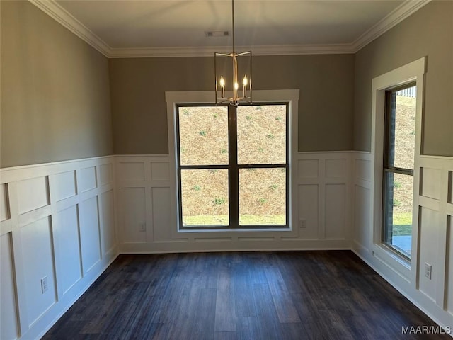 unfurnished dining area featuring a chandelier, a wealth of natural light, crown molding, and dark wood-type flooring