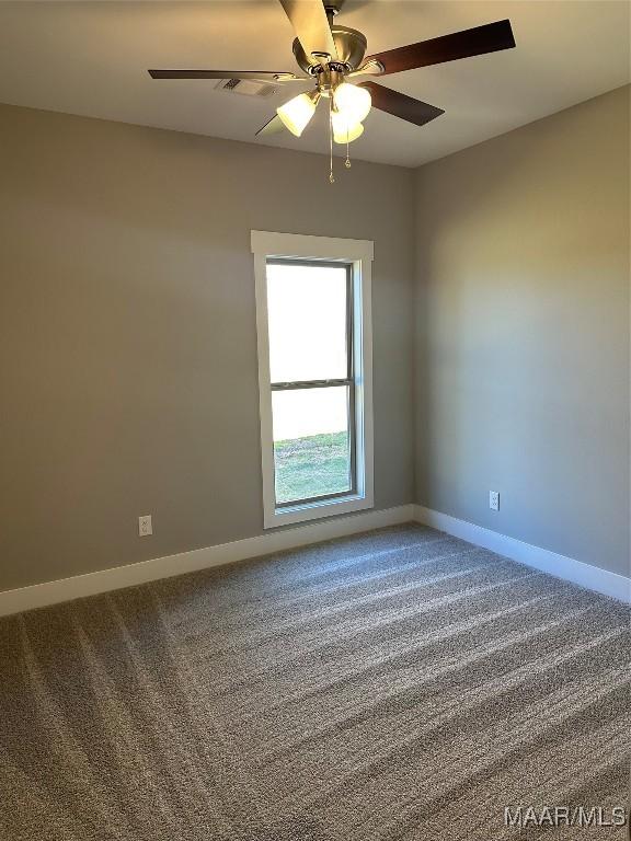 spare room with a ceiling fan, carpet flooring, and baseboards