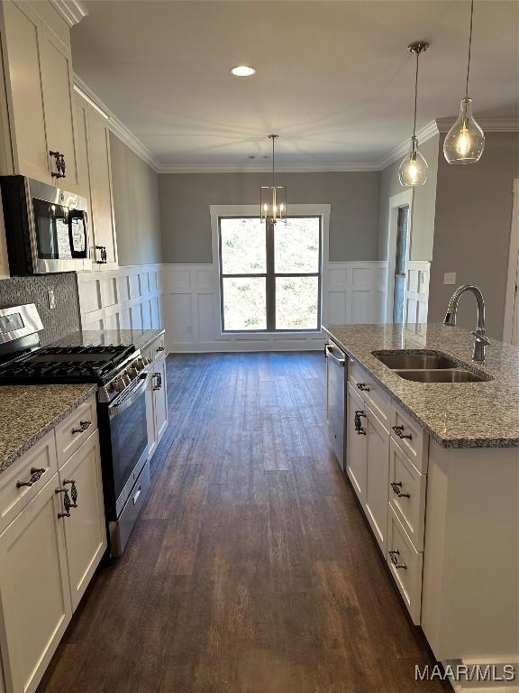 kitchen with ornamental molding, appliances with stainless steel finishes, and a sink