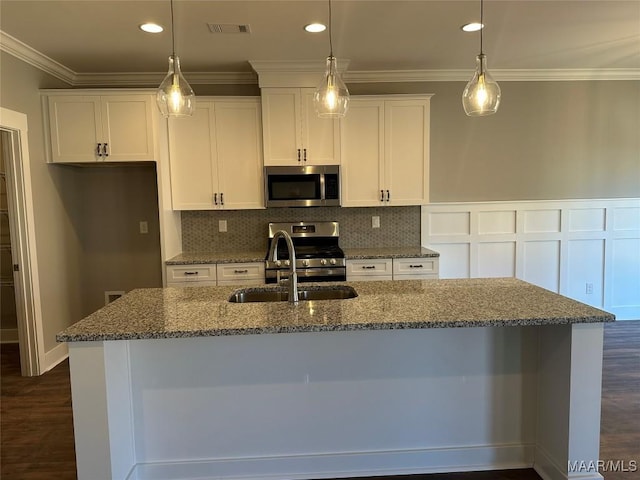 kitchen featuring visible vents, appliances with stainless steel finishes, ornamental molding, white cabinetry, and a sink