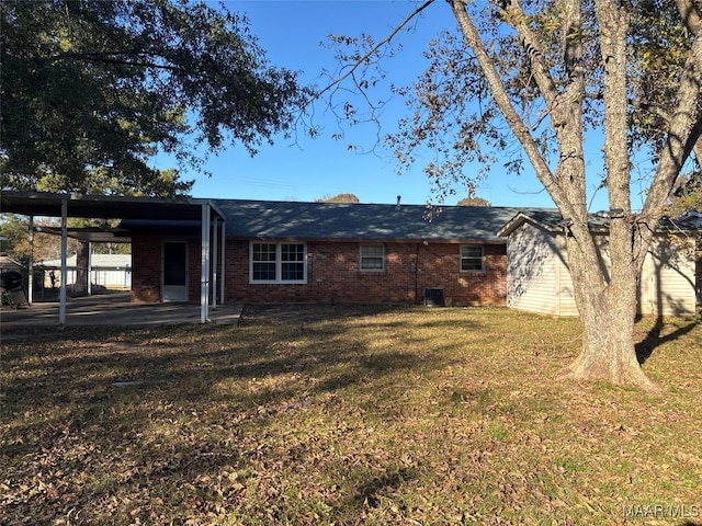 rear view of house featuring a yard and a carport