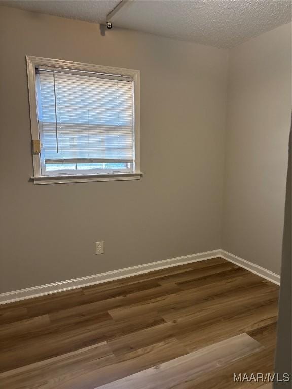 spare room with hardwood / wood-style floors and a textured ceiling