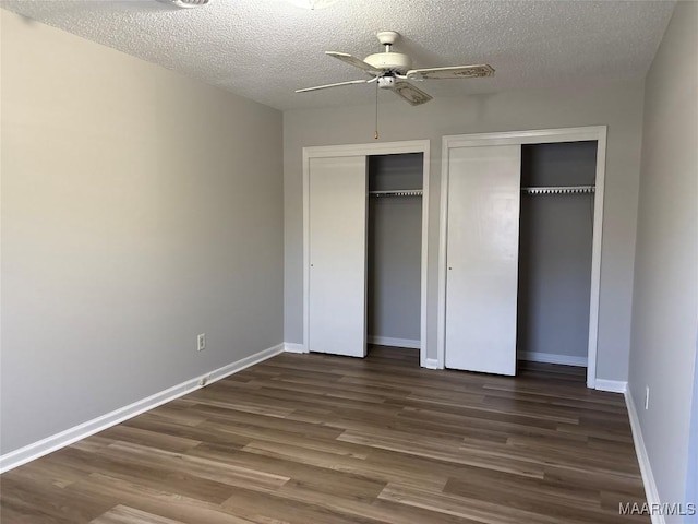 unfurnished bedroom featuring a textured ceiling, ceiling fan, and dark wood-type flooring