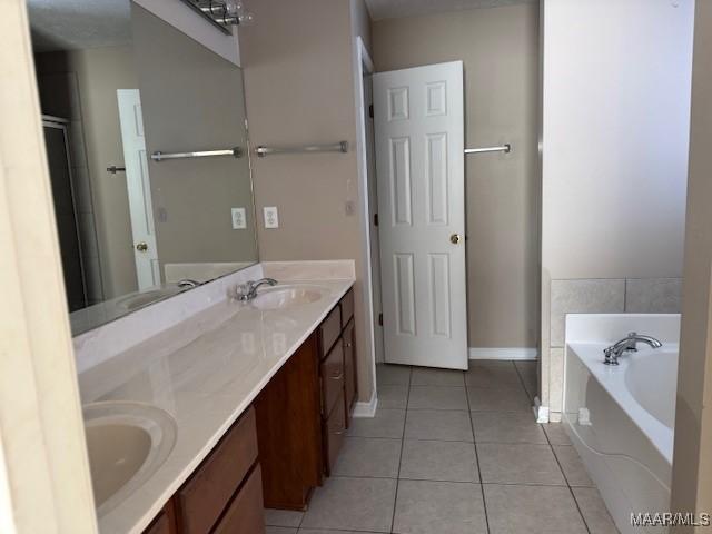 bathroom with tile patterned flooring, vanity, and a washtub