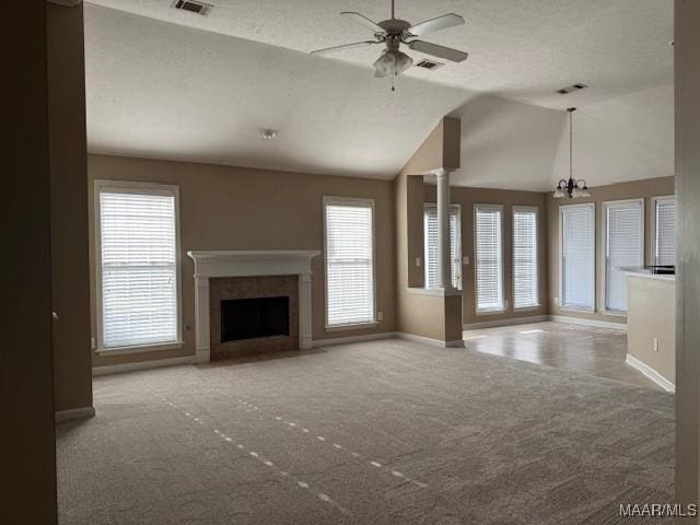 unfurnished living room with carpet flooring, a textured ceiling, ceiling fan with notable chandelier, and lofted ceiling