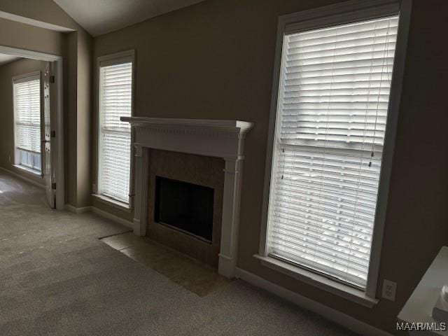 unfurnished living room with carpet floors and vaulted ceiling