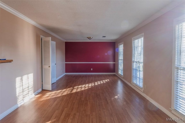 spare room featuring hardwood / wood-style floors, a textured ceiling, and ornamental molding