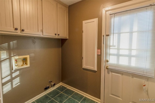 washroom featuring gas dryer hookup, hookup for a washing machine, cabinets, and dark tile patterned flooring