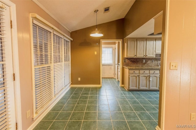 kitchen featuring light brown cabinets, dark tile patterned floors, backsplash, decorative light fixtures, and vaulted ceiling